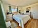 Bedroom with a queen bed, wood floors, and a large window provides a warm and inviting ambiance at 1633 Leisure Dr # M-37, Bradenton, FL 34207