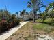 Charming one-story home featuring a lush, landscaped front yard with mature palm trees and a cozy porch area at 1633 Leisure Dr # M-37, Bradenton, FL 34207