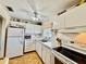 Bright kitchen features white appliances, light countertops, ample cabinets, and a ceiling fan at 1633 Leisure Dr # M-37, Bradenton, FL 34207