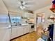 Well-lit kitchen featuring white cabinets and appliances, with view into a cozy dining area at 1633 Leisure Dr # M-37, Bradenton, FL 34207