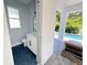 View into an outdoor bathroom with a stylish vanity and a window, connecting to an outdoor pool area at 1647 Siesta Dr, Sarasota, FL 34239