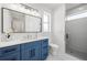 Bathroom with a single vanity, framed mirror, and walk-in shower at 1647 Siesta Dr, Sarasota, FL 34239