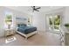 Sunlit bedroom with a ceiling fan, balcony access, and light wood floors at 1647 Siesta Dr, Sarasota, FL 34239