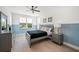 Comfortable bedroom with decoratively painted walls, ceiling fan, and wood floors at 1647 Siesta Dr, Sarasota, FL 34239