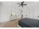 Spacious bedroom with modern decor, ceiling fan and view to the bathroom at 1647 Siesta Dr, Sarasota, FL 34239