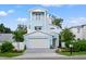 Charming light blue two-story home boasting a balcony, a manicured lawn, and a two car garage at 1647 Siesta Dr, Sarasota, FL 34239
