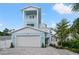 Charming light blue two-story home featuring a spacious two-car garage and a manicured front yard at 1647 Siesta Dr, Sarasota, FL 34239
