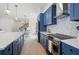 Modern kitchen with stainless steel appliances, sleek blue cabinetry, and light wood flooring at 1647 Siesta Dr, Sarasota, FL 34239