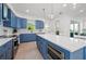 Bright kitchen with blue cabinets, stainless steel appliances, white countertops, and ample natural light at 1647 Siesta Dr, Sarasota, FL 34239