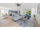 Bright open-concept living room featuring modern furnishings, a ceiling fan, and sliding glass doors leading outdoors at 1647 Siesta Dr, Sarasota, FL 34239