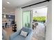 Cozy living room featuring a plush chair with views of the kitchen and outdoor dining area and pool beyond at 1647 Siesta Dr, Sarasota, FL 34239