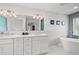 Luxurious main bathroom featuring a double vanity, modern fixtures, marble accents, and a freestanding tub at 1647 Siesta Dr, Sarasota, FL 34239