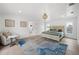 Bright main bedroom with wood-look floors, decorative chandelier, and ensuite bathroom at 1647 Siesta Dr, Sarasota, FL 34239