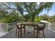 Outdoor seating with wooded backyard views from a second story porch featuring a white railing at 1647 Siesta Dr, Sarasota, FL 34239