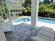 Relaxing pool area featuring an in-ground pool, jacuzzi, spiral staircase, and an outdoor lounge area at 1647 Siesta Dr, Sarasota, FL 34239