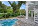 The backyard features a pool, lounge chairs, and lush tropical landscaping at 1647 Siesta Dr, Sarasota, FL 34239