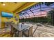This stylish lanai has an outdoor TV, dining area, fire pit, and comfortable seating area at 1709 6Th E St, Palmetto, FL 34221