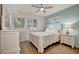 Bright bedroom with white furniture, wood floors, light blue accent wall, and window shutters at 17626 Gawthrop Dr # 305, Bradenton, FL 34211