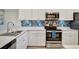 Kitchen with stainless steel appliances, white cabinets, quartz counters and a colorful backsplash at 17626 Gawthrop Dr # 305, Bradenton, FL 34211