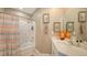 Inviting bathroom with striped shower curtain and a framed mirror over the sink at 1771 Ringling Blvd # 1212, Sarasota, FL 34236