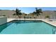 Inviting pool area boasts sparkling water, palm trees, lounge chairs, and lush landscaping at 1771 Ringling Blvd # 1212, Sarasota, FL 34236