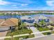 Beautiful aerial view of homes with lake views, tropical landscaping, and paver driveways in a well maintained community at 17966 Grand Prosperity Dr, Venice, FL 34293
