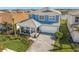 Aerial view of a beautiful two-story home with a paver driveway, covered porch, and a manicured lawn at 17966 Grand Prosperity Dr, Venice, FL 34293