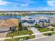 Wide aerial view of a neighborhood featuring waterfront homes, lush green lawns, and a beautiful community lake at 17966 Grand Prosperity Dr, Venice, FL 34293