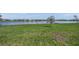 Expansive grassy backyard with a tranquil lake view, perfect for outdoor activities and relaxation at 17966 Grand Prosperity Dr, Venice, FL 34293