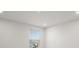 Bright bedroom with white walls, recessed lights, and a window overlooking the street at 17966 Grand Prosperity Dr, Venice, FL 34293