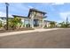 Modern clubhouse exterior with palm trees and a covered entrance, providing an inviting community gathering space at 17966 Grand Prosperity Dr, Venice, FL 34293