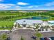 Aerial view of the community center overlooking a serene lake and lush landscaping, including a swimming pool at 17966 Grand Prosperity Dr, Venice, FL 34293