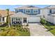 Inviting two-story home with a covered porch, chairs, a paver driveway, and a two-car garage at 17966 Grand Prosperity Dr, Venice, FL 34293