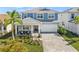 Inviting two-story home with a covered porch, chairs, a paver driveway, and a two-car garage at 17966 Grand Prosperity Dr, Venice, FL 34293