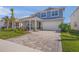 Charming two-story home featuring a well-manicured lawn, paver driveway, and an attached two-car garage at 17966 Grand Prosperity Dr, Venice, FL 34293