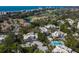 Gorgeous aerial view of condos with blue awnings, landscaping, and the Gulf of Mexico in the background at 1912 Harbourside Dr # 602, Longboat Key, FL 34228