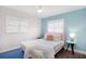 Colorful bedroom features a plush bed, light blue accent wall and natural light at 2001 25Th W Ave, Bradenton, FL 34205