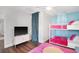 Bright bedroom featuring a bunk bed, television, plush pink rug, and vibrant blue walls at 2001 25Th W Ave, Bradenton, FL 34205
