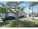 View of this single-story home's charming curb appeal, including mature trees and a well-maintained lawn at 2001 25Th W Ave, Bradenton, FL 34205