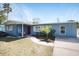 Charming single-story home with a blue exterior, red door, and well-maintained front yard at 2001 25Th W Ave, Bradenton, FL 34205