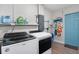 A tidy laundry room with washer, dryer, storage shelves and a blue door at 2001 25Th W Ave, Bradenton, FL 34205