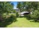 Serene backyard view with a bridge over the river and the house behind the trees at 2003 12Th W Ave, Bradenton, FL 34205