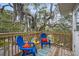Balcony featuring Spanish moss trees and blue Adirondack chairs with orange pillows at 2003 12Th W Ave, Bradenton, FL 34205