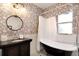 Elegant bathroom featuring a clawfoot tub with shower, stylish vanity, and decorative wallpaper at 2003 12Th W Ave, Bradenton, FL 34205