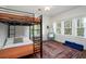 Fun bedroom with a bunk bed, hanging chair, and large windows with a view of trees at 2003 12Th W Ave, Bradenton, FL 34205