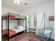 Charming bedroom featuring bunk beds, a cozy hanging chair, and natural light from the large windows at 2003 12Th W Ave, Bradenton, FL 34205