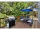 Outdoor dining area on a wooden deck, complete with a grill and umbrella for shaded relaxation at 2003 12Th W Ave, Bradenton, FL 34205