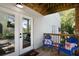 Inviting porch with cozy blue chairs and a charming floral cushions near glass paneled doors at 2003 12Th W Ave, Bradenton, FL 34205