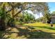 Expansive backyard with mature trees providing shade, a tire swing, and a fenced area for privacy at 2070 59Th St, Sarasota, FL 34243