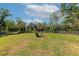 Expansive fenced backyard features a lush green lawn and mature trees for privacy at 2070 59Th St, Sarasota, FL 34243